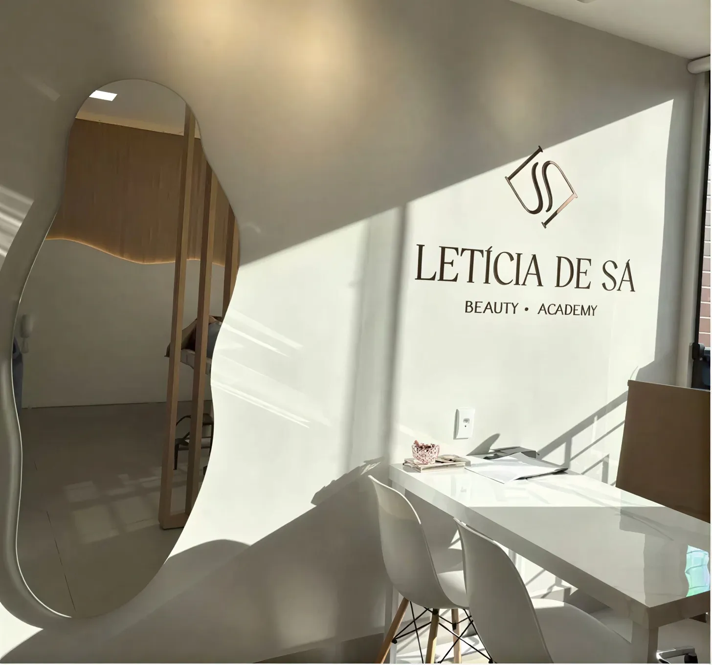Recepção do estúdio Letícia de Sá, com espelho e logo na parede